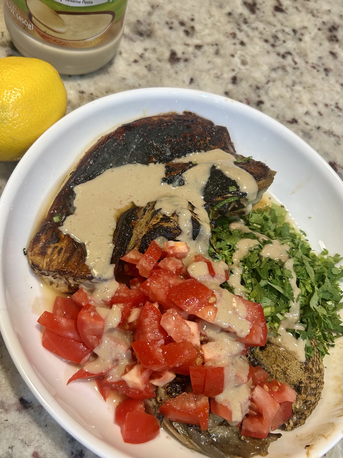 Roasted eggplant with tahini, tomato, coriander, lemon, and spices